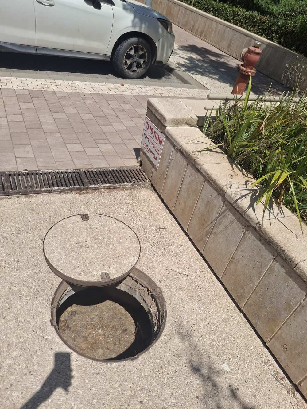 שוחת ביוב פתוחה בחצר פרטית של בניין מגורים